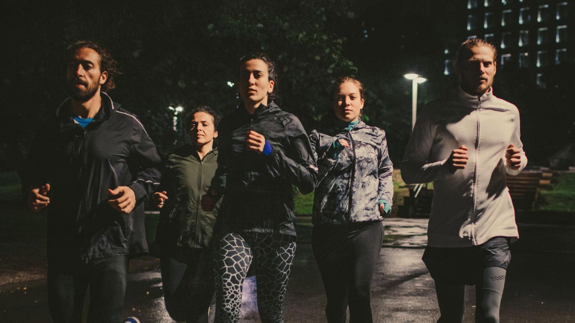 Photo of people in running attire, jogging purposefully toward camera.