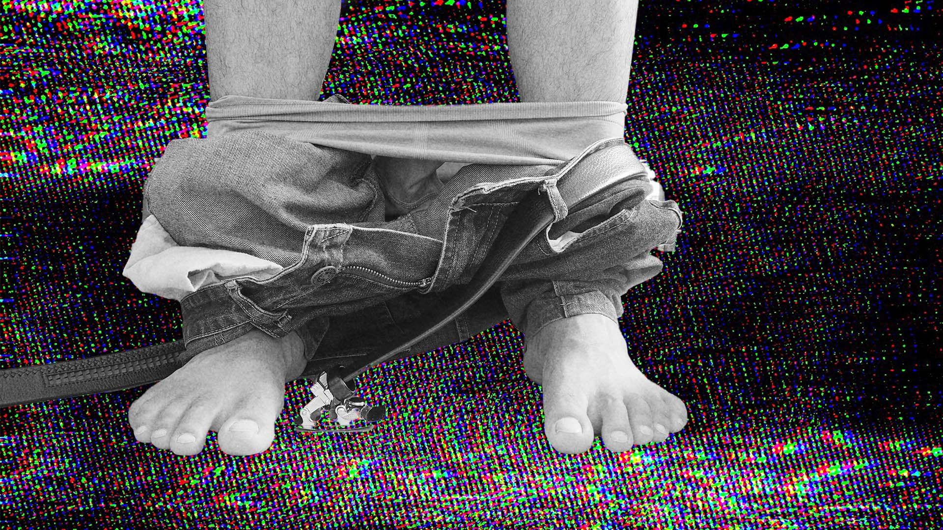 Jeans around a man's ankles.